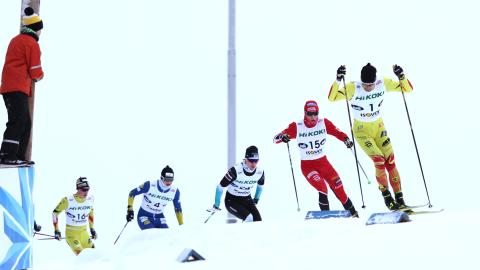 Hiihtäjiä ladulla. lapsi on kiivennyt korokkeelle seuraamaan kilpailua.