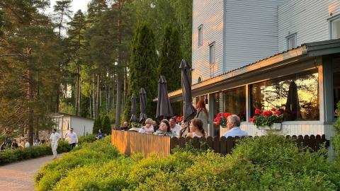 A white funky-style building with a glazed terrace in the foreground.