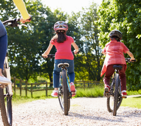 KAksi aikuista ja kaksi lasta pyöräilemässä